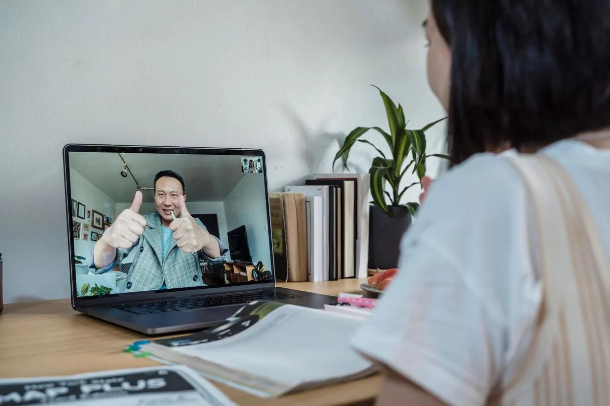 A student taking part in a live session over a video call on a laptop